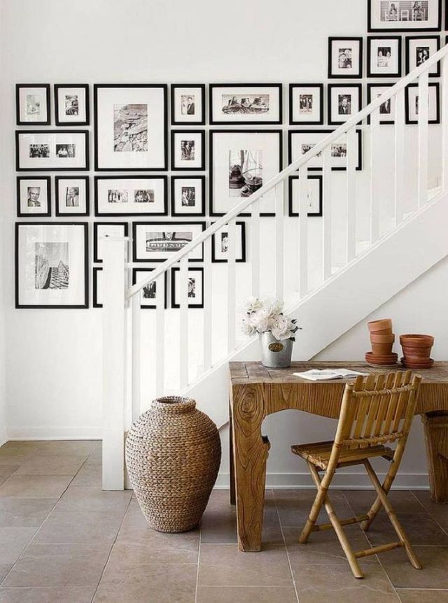mur blanc de cadres noirs derrière un escalier blanc