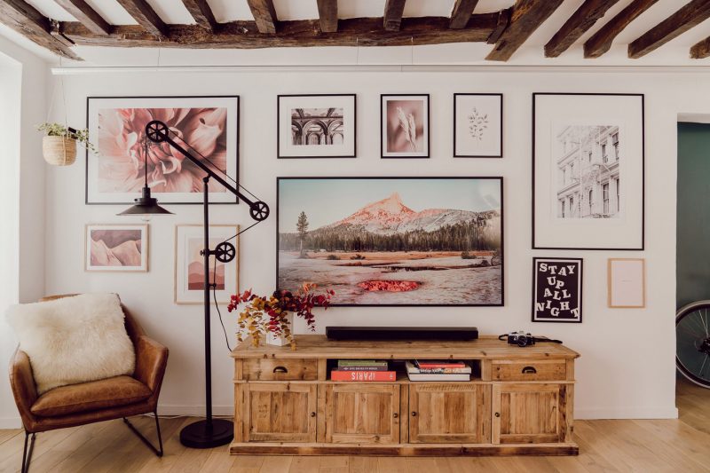 mur avec illustrations de couleurs dans salon rustique avec mobilier en bois