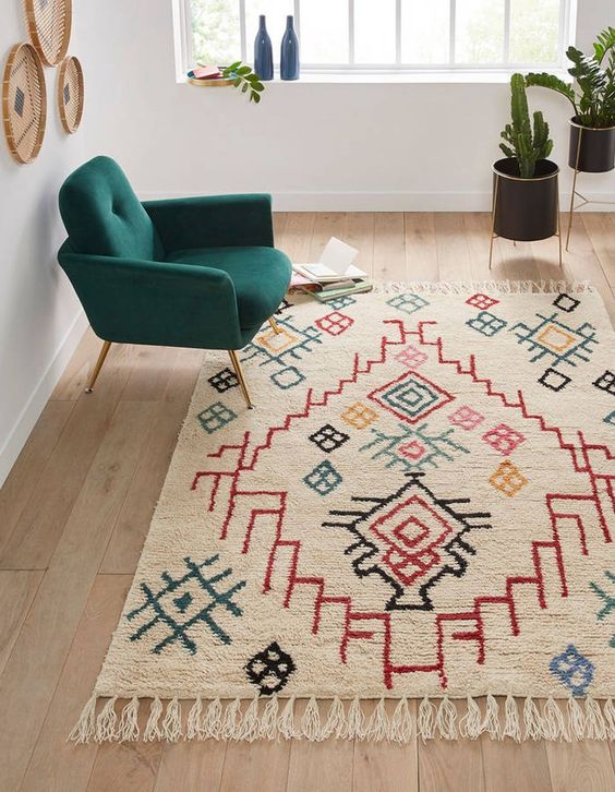 tapis navajo sous fauteuil vert émeraude dans pièce claire de déco bohème