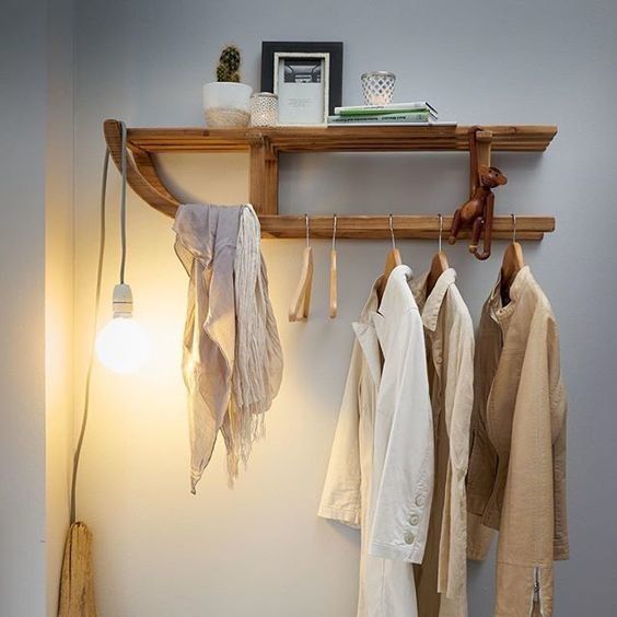 vêtements accrochés à des portants sur une luge en bois au mur