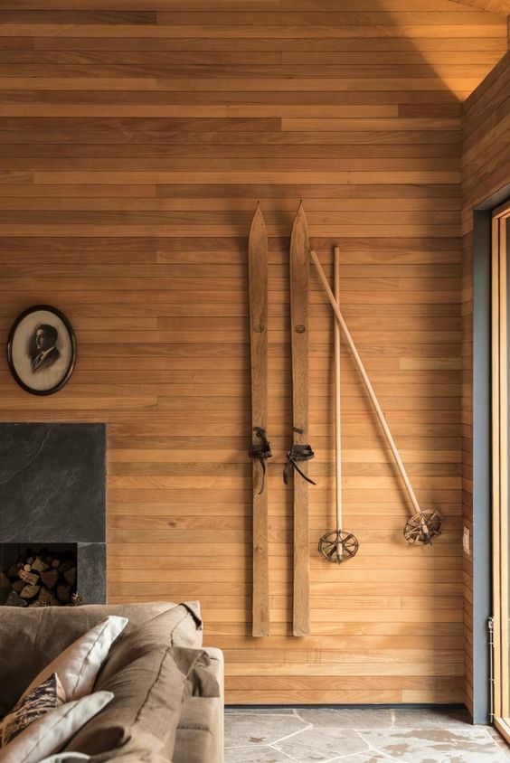 skis en bois accrochés sur un mur en bois dans un chalet