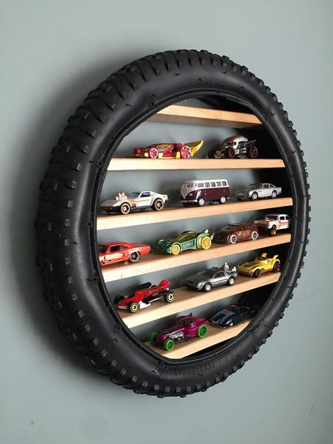 voitures miniatures rangées sur des étagères en bois dans un pneu accroché au mur