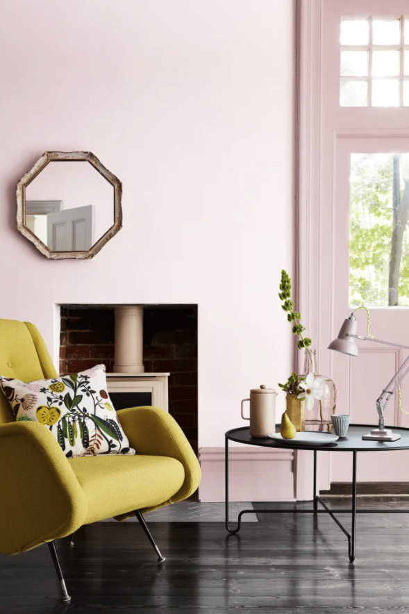fauteuil jaune moutarde dans un salon cosy chic au mur rose
