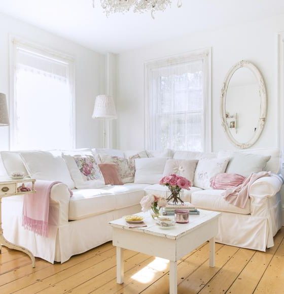 un grand canapé classique en blanc décoré de coussins roses et blancs dans une pièce classique au mobilier en bois
