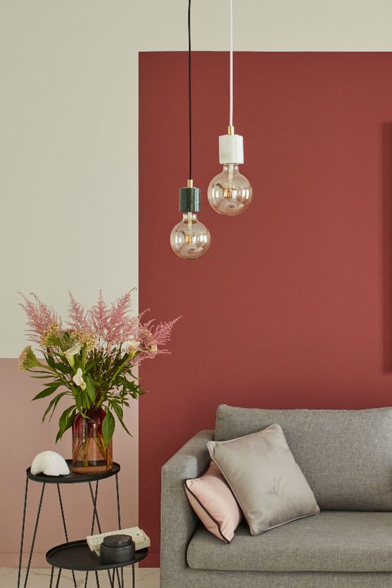 ampoules suspendues dans un salon cosy chic au mur peint couleur terracotta