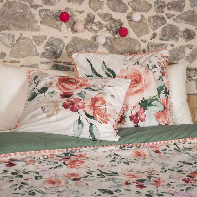 des coussins et des draps de lit à motifs fleuris en rose et vert