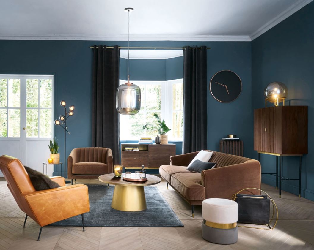 salon de style art déco avec canapé et fauteuils en velours marrant et table basse arrondie dorée