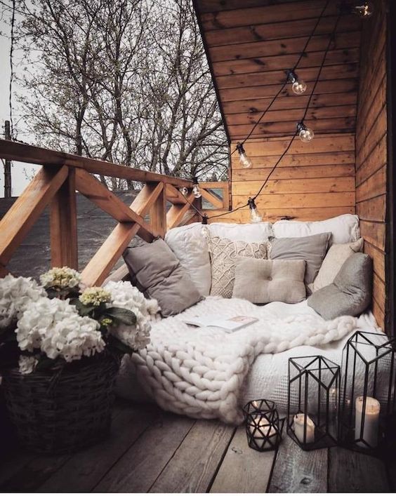 coussins et plaids confortables pour créer un coin lecture cocooning sur un balcon en bois