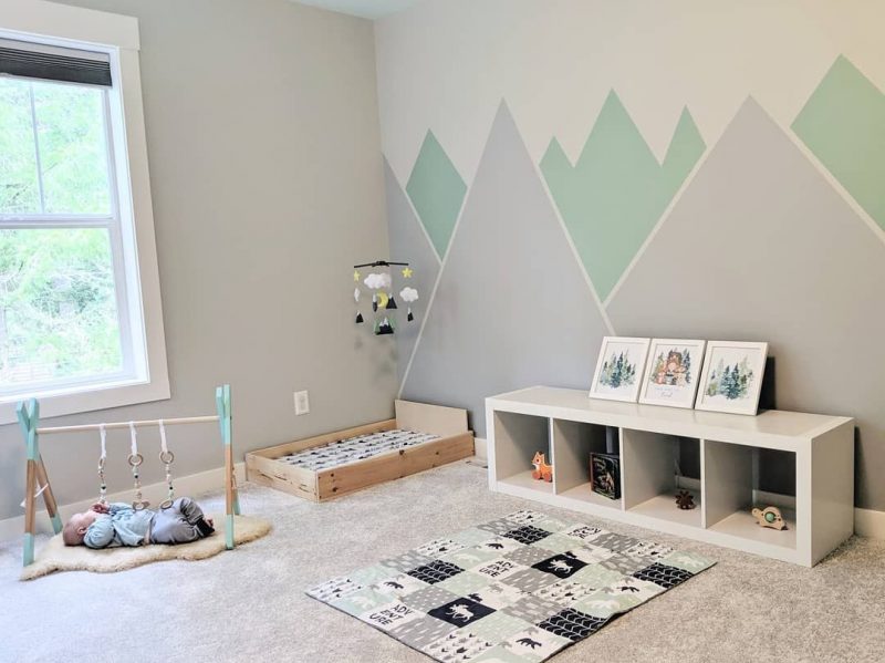 chambre bébé montessori de couleurs pastel avec graphiques au mur