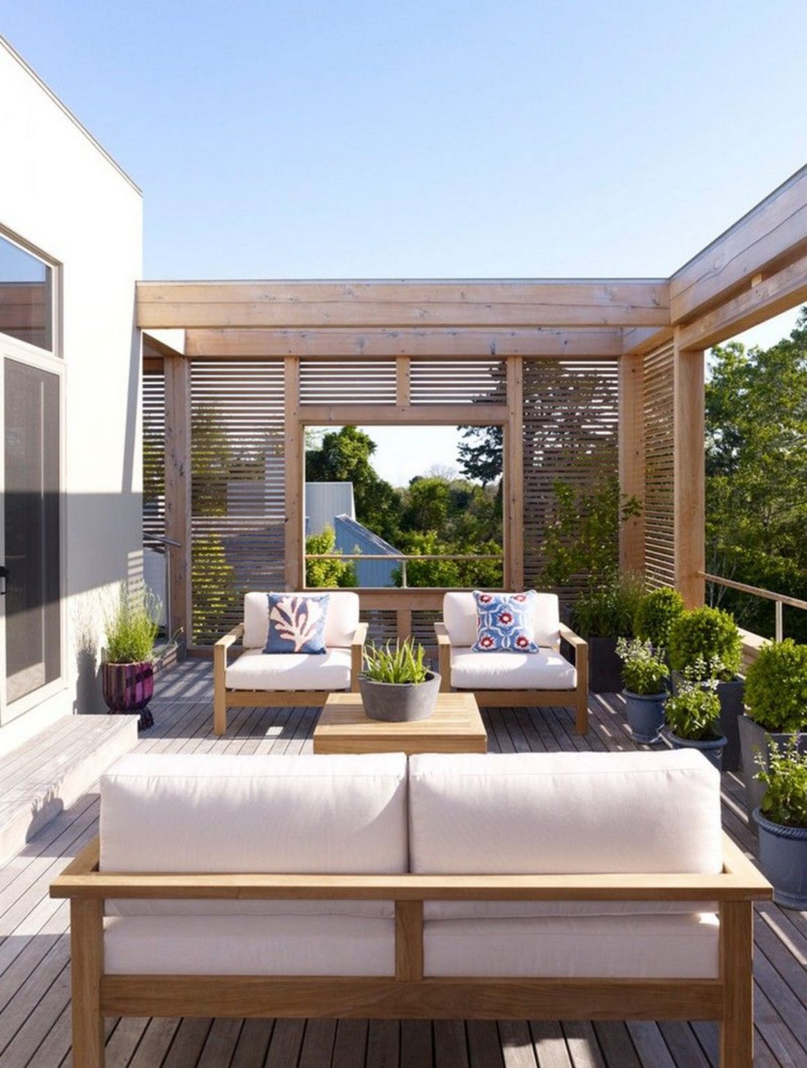 aménagement terrasse chic et cosy avec cloisons en bois et coussins blancs