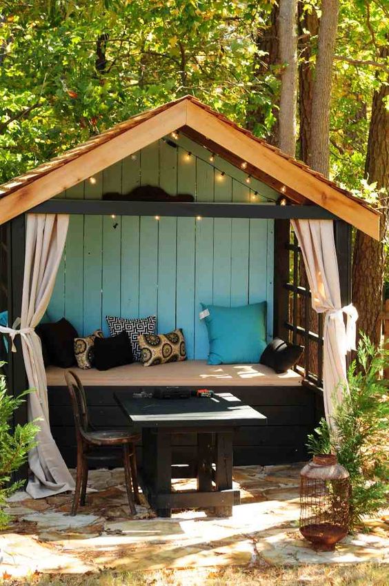 coin cosy avec matelas et coussins dans une cabane en bois surélevée