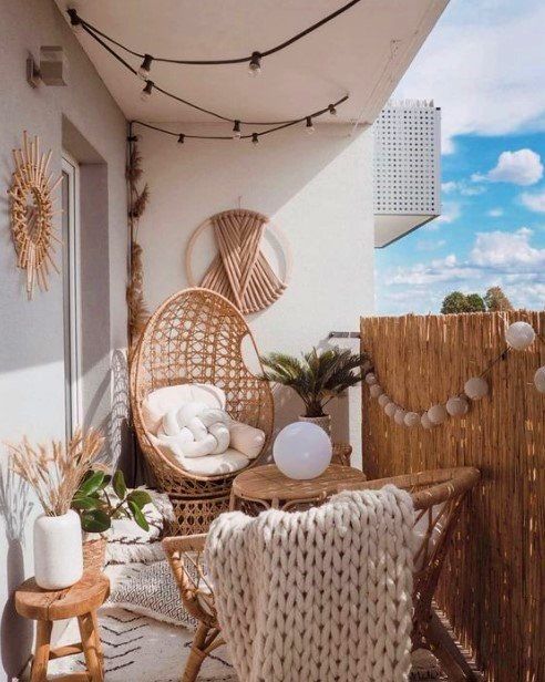 ambiance bohème avec mobilier en osier et objets blancs sur un balcon lumineux