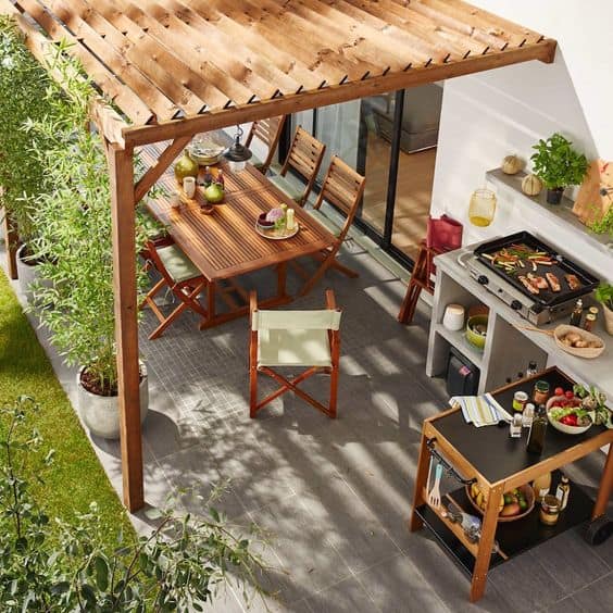 aménager une terrasse avec une plancha et une table sous un abris en bois