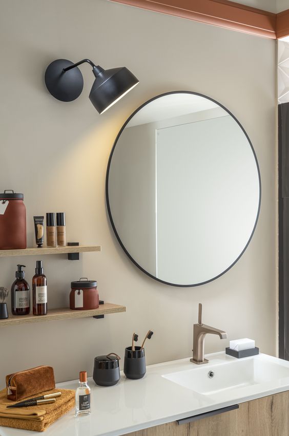 lampe tendance éclairant un miroir de salle de bains