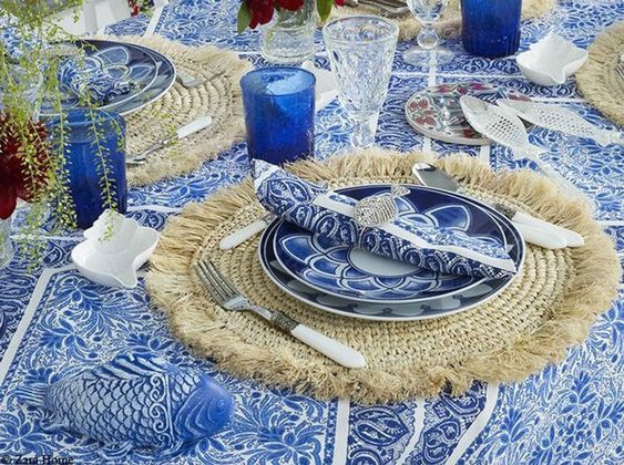 décoration de table de style bord de mer avec vaisselle bleue et sous plats en osier