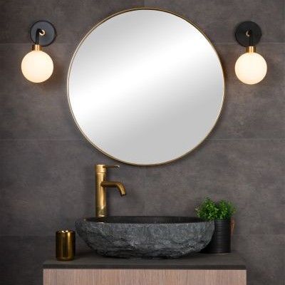 luminaires tendance autour d'un miroir doré de salle de bains