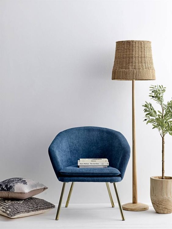 lampadaire en matériaux naturels clairs pour illuminer un fauteuil bleu foncé