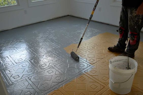 repeindre le sol d'une pièce avec rouleau de peinture