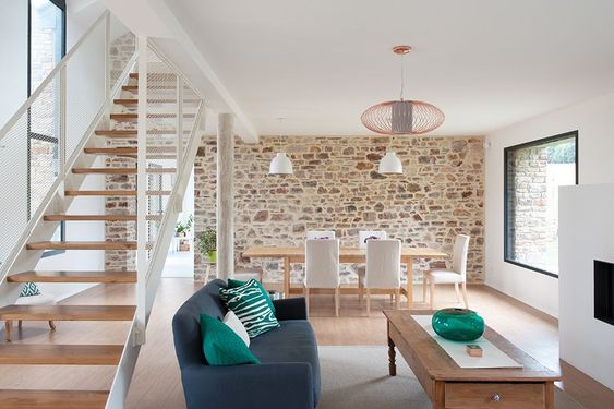 un espace ouvert moderne avec mobilier contemporain et mur en pierre apparente