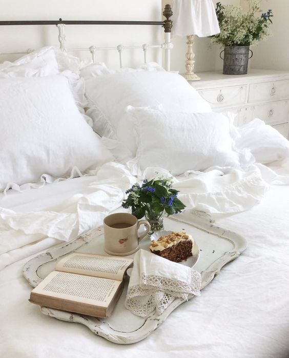 coussins et draps blancs sur un lit à tête métallique