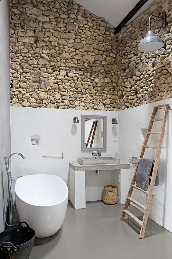 salle de bains rustique avec échelle décorative en bois et mur en pierre irrégulière