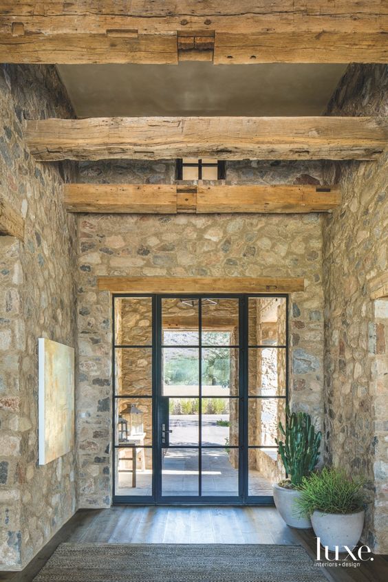 large couloir dans maison de campagne avec murs en pierre