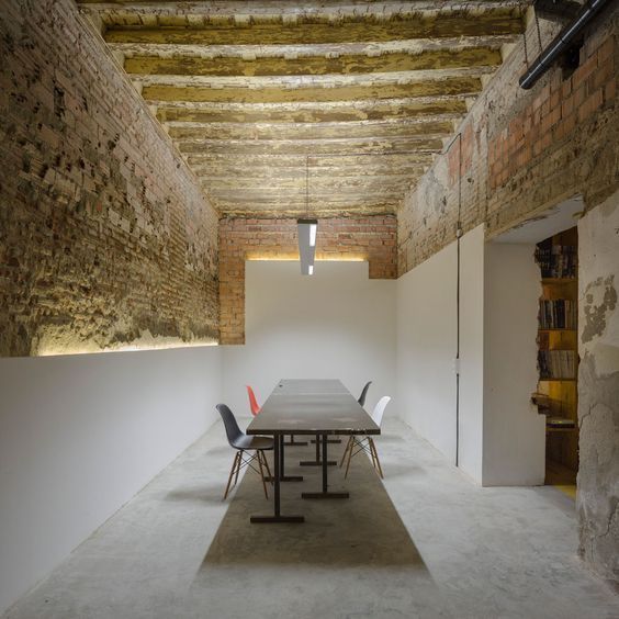 une grande table dans une pièce en cave avec un toit et des murs en pierre
