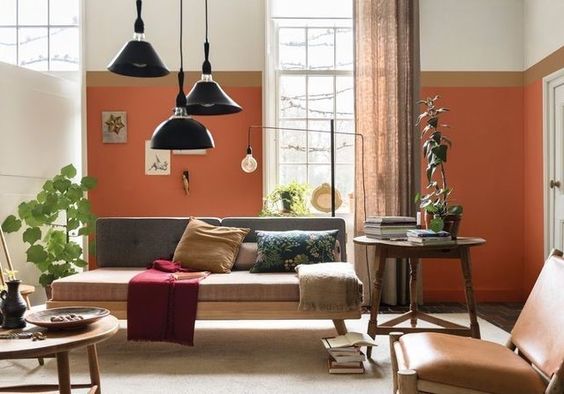 salon vintage avec luminaires noirs et mur peint en orange