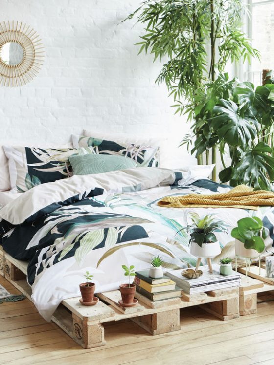 plantes décoratives dans une chambre à lit en palettes de bois