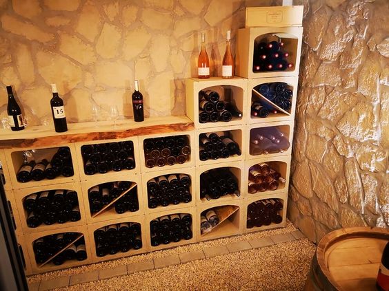 bouteilles de vin rangées dans des caisses en bois dans une cave