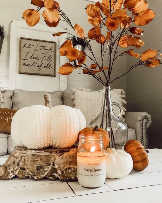 citrouille blanche en laine et fleurs séchées orange dans un vase transparent pour une déco automne du salon