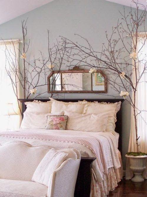 tête de lit avec des branchages autour d'un grand lit rustique en bois