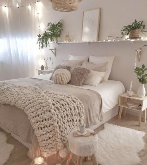 plaid en crochet au dessus d'un lit avec draps blancs et beiges dans une chambre déco cocooning