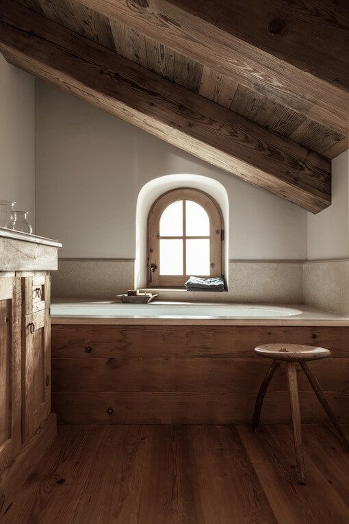 bain en céramique dans structure en bois brut dans salle de bains de chalet