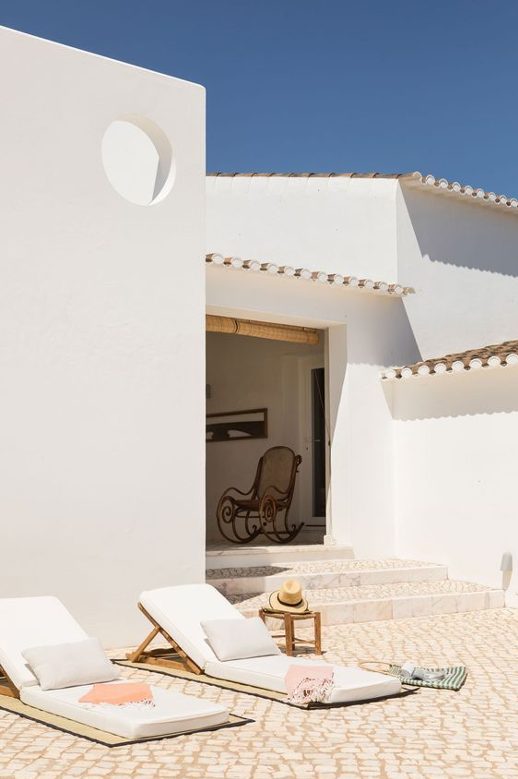 terrasse dans une maison portugaise avec murs blancs et mobilier en matériau naturel