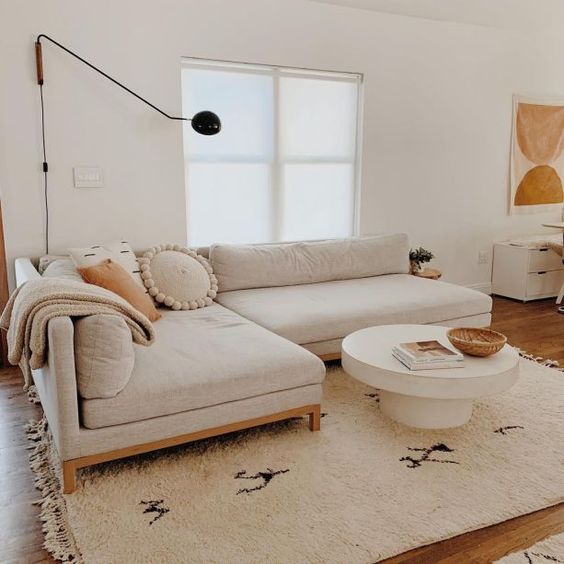 salon déco californienne avec canapé d'angle beige sur grand tapis berbère