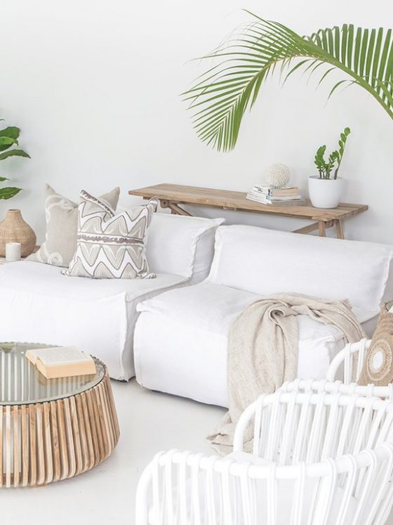 canapé et mobilier blanc dans un salon déco californienne avec plantes vertes en objets en bois