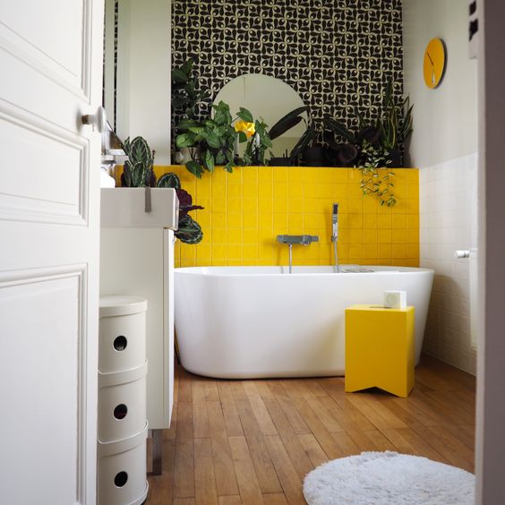 carreaux de faïence jaune dans une salle de bains végétale au sol en bois