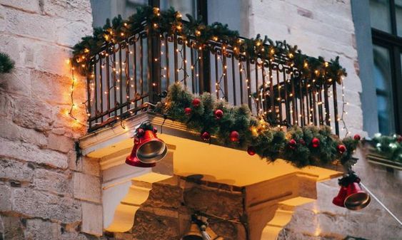déco lumineuse de Noël sur un balcon avec guirlandes et branchages