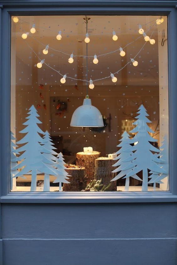 déco lumineuse Noël avec guirlande lumineuse au dessus d'une fenêtre décorée de mini sapins en papier