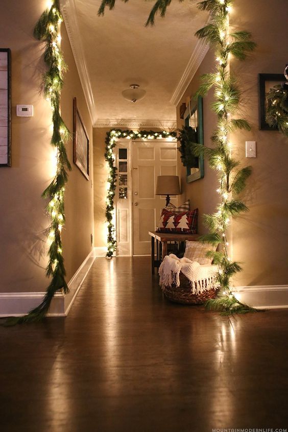 guirlandes lumineuses et branches de sapin pour décorer les murs d'une maison
