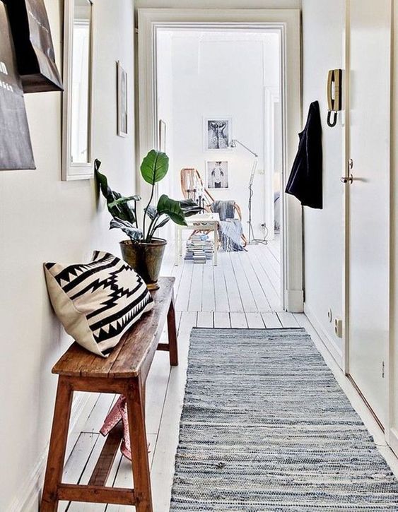 aménagement couloir blanc avec banc en bois et plante décorative