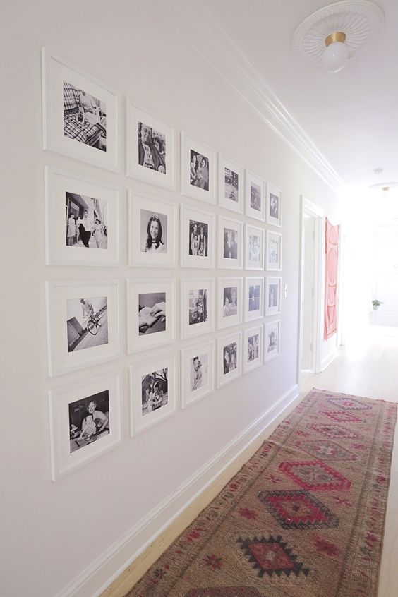 mur de cadres avec photographies noir et blanc en aménagement couloir