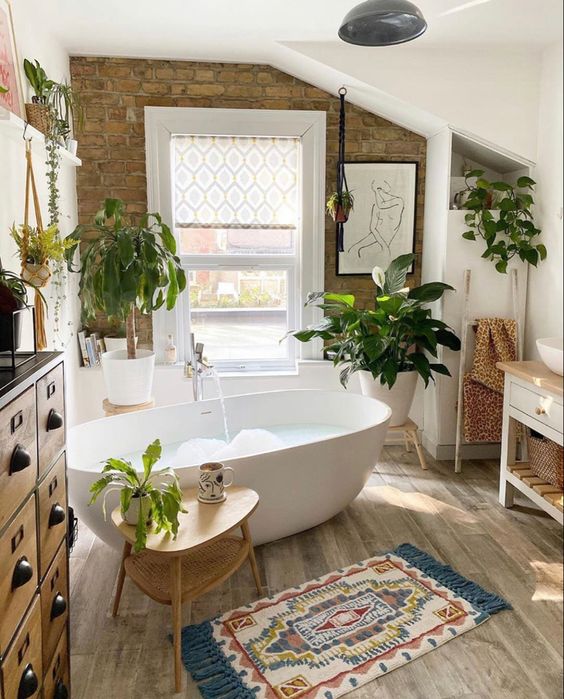 tapis ethnique sous une baignoire blanche en céramique dans une salle de bains décorée de plantes vertes