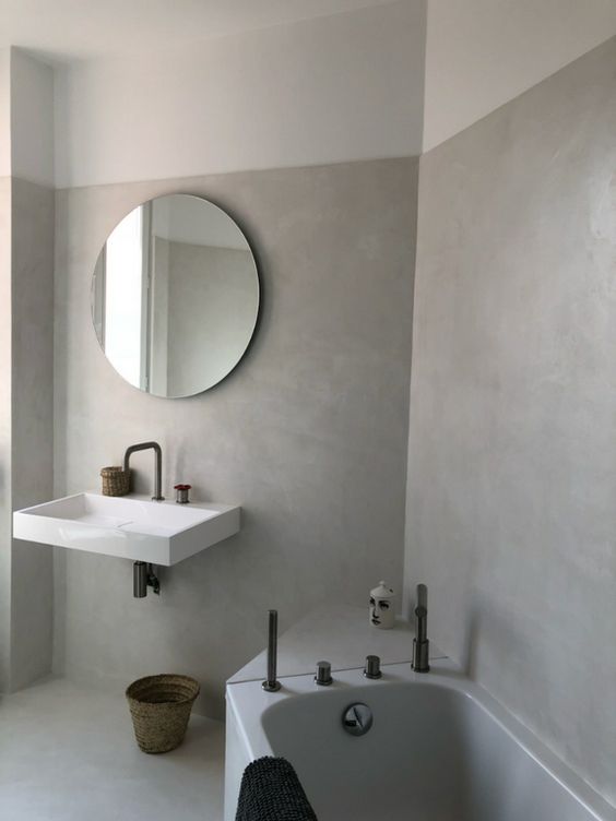 salle de bains moderne avec mur en béton ciré et robinetterie argentée