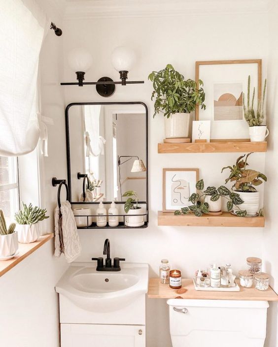 plantes décoratives et produits de bains sur des étagères en bois pour aménager une petite salle de bains