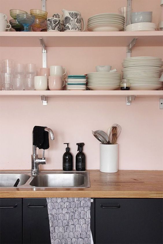 vaisselle sur des étagères en bois dans une cuisine de couleur rose bonbon