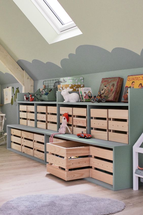 jouets et livres au dessus d'un rangement chambre bébé vert avec caisses en bois