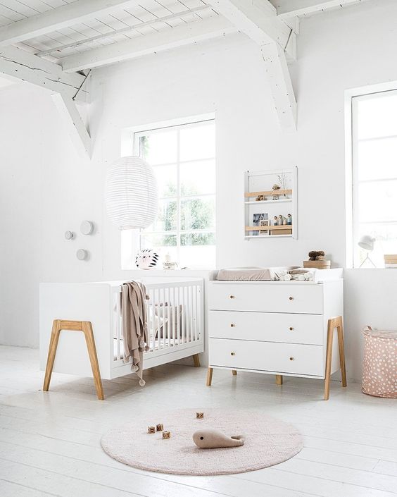 lit et commode table à langer en bois blanc dans une chambre bébé claire
