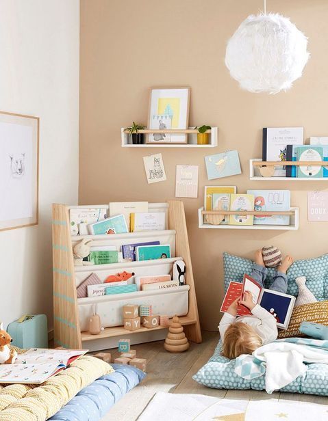 chambre bébé avec rangements pour livres sur étagères et en bibliothèque sur roulettes
